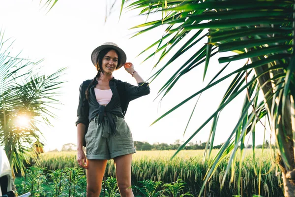 巴厘岛阳光明媚的日子里 身穿夏装 头戴草帽 背着背包 站在稻田边 看上去很开心 — 图库照片
