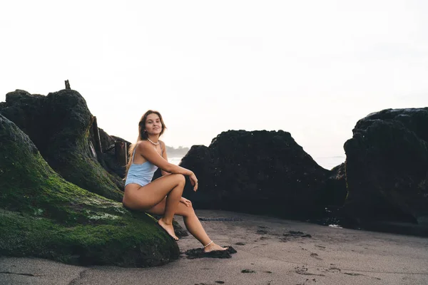 Side View Full Body Barefoot Relaxed Woman Sitting Stone Looking — стоковое фото