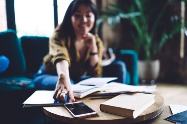 Bulanık kız öğrencinin kullandığı modern cep telefonu aygıtı, akıllı telefon uyarısını kontrol eden kadın veya kapalı alandaki 4G kablosuz internete bağlı cep telefonu mesajı