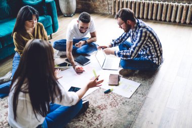 Genç bir grup profesyonel grafik tasarımcısı, plan taslağını tartışmak için beyin fırtınası sırasında konuşuyorlar. Yetenekli erkek ve kız öğrenci. Sınavlara birlikte hazırlanıyorlar ve öğreniyorlar.