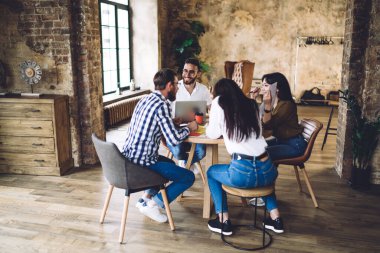 Çatı katında işbirliği yapan mutlu çok ırklı öğrenciler öğrenim amaçlı arkadaşça buluşmanın keyfini çıkarıyorlar. 20 'li yaşlardaki yetenekli hippi gençler serbest projeksiyon ve verimli uzaktan kumanda işini tartışıyorlar.