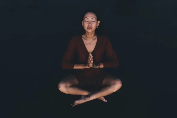 ヨガをしながら暗闇の中で瞑想を練習し 沈黙を楽しんでいる穏やかなアジアの女性の完全な体と練習中にリラックス — ストック写真