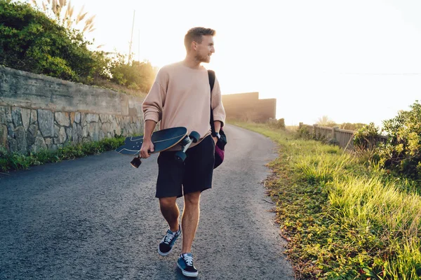 Χαμογελώντας Καυκάσιος Άνδρας Casual Φορούν Περπάτημα Ασφαλτοστρωμένο Δρόμο Στην Ύπαιθρο — Φωτογραφία Αρχείου