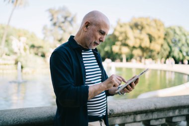 Kafkas erkek son sınıf öğrencisi modern ağ yayınlarını okumak ve online rezervasyon yapmak için 4G internet kullanıyor, 60 'lı yaşlarda yaşlı bir adam dokunmatik sayfalarda sohbet sırasında gelen mesaj bültenini kontrol ediyor