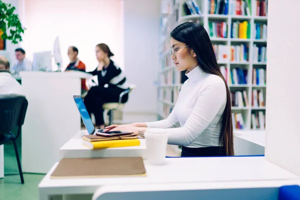 안경을 컴퓨터로 타이핑을 도서관에 책상에 정보를 검색하는 여성의 — 스톡 사진