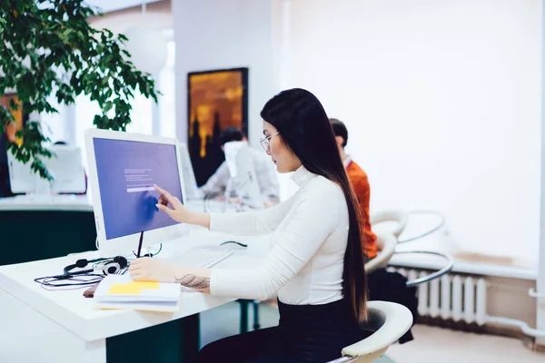 터틀넥을 여성의 과검은 바지가 정보를 테이블에 컴퓨터 화면에 — 스톡 사진