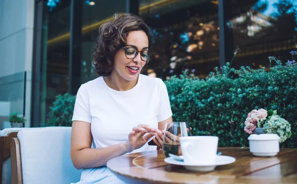 Cheerful Young Brunette Wearing White Shirt Eyeglasses Browsing Internet Mobile — Stockfoto