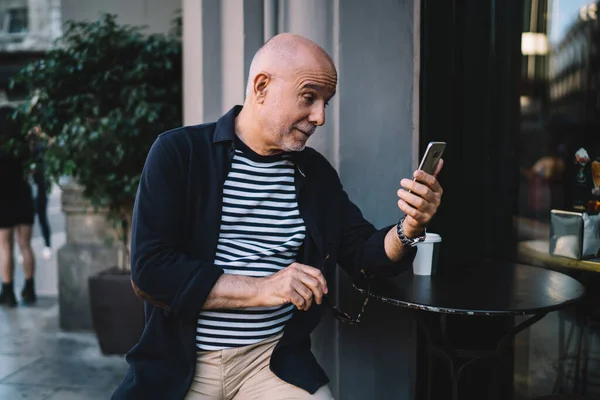 Bilmece gibi erkek kıdemli okumalar e-posta yoluyla bilgi verici internet haberleriyle şok olmuş, sosyal medya ve internet sitesinde yayınlanmak için akıllı telefon uygulaması kullanan beyaz adam emekli olmuş.