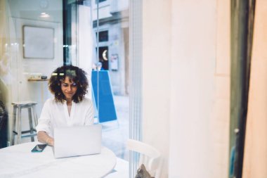 Laptop uygulaması üzerinden öğrenmek için video webinar izleyen çekici kadın serbest yazar, içerik yayınını taramak ve metin okumak için wifi internete bağlanan yetenekli blog yazarı