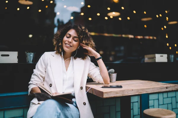 Cheerful Hipster Girl Checking Informative Notes Textbook While Listening Audio — Fotografia de Stock