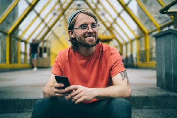 Pemuda Trendi Hipster Bertopi Tersenyum Dan Melihat Jauh Memegang Ponsel — Stok Foto
