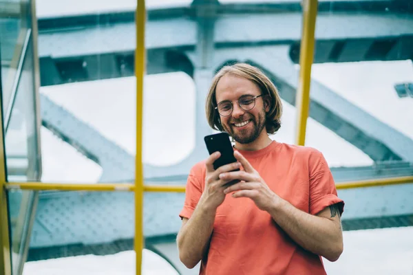 Cheerful Unshaven Adult Man Glasses Orange Shirt Holding Smartphone While — Stockfoto