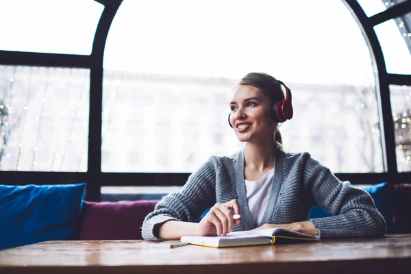 Pleasant Woman Casual Listening Music Headphones Smiling While Taking Notes — Stock Photo, Image