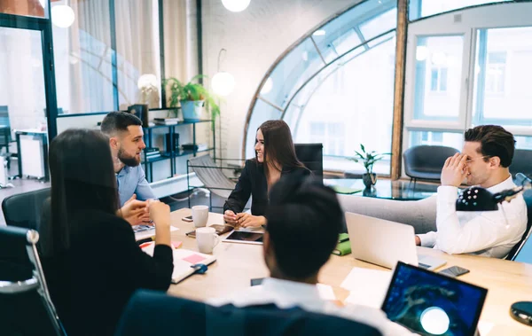 Group Cheerful Business Partners Sitting Table Laptops Tablets While Discussing — 图库照片