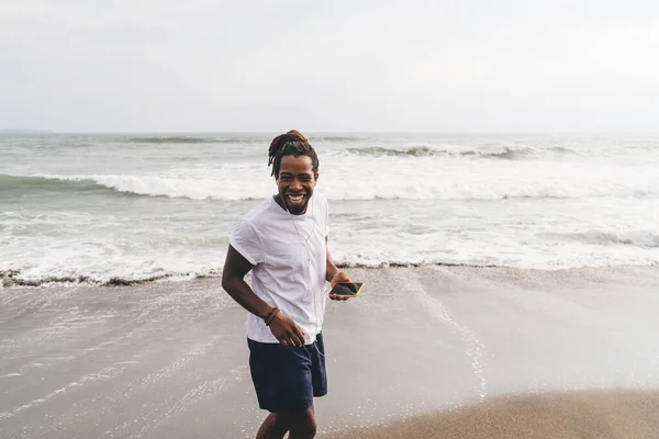 Neşeli Afrika Kökenli Amerikalı Erkek Rahat Giyiniyor Gülümsüyor Kumsalda Müzik — Stok fotoğraf