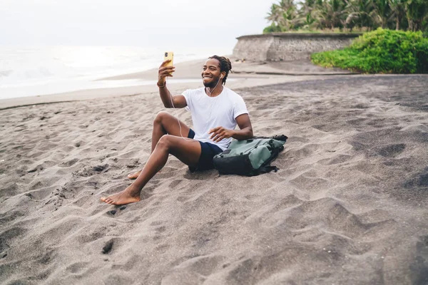 Młody Czarny Mężczyzna Podróżujący Luźnych Ubraniach Plecakiem Uśmiechnięty Komunikujący Się — Zdjęcie stockowe