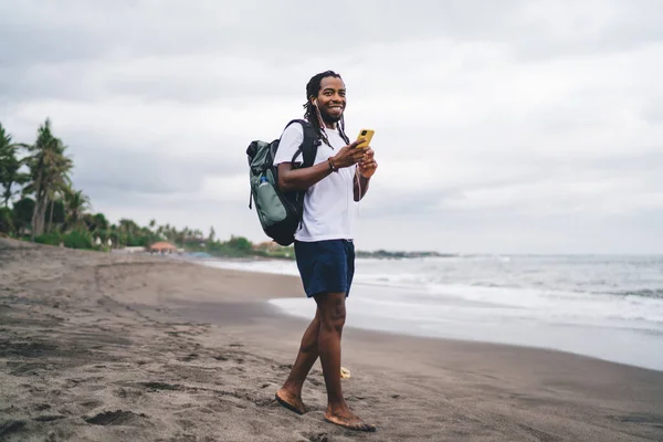 Sırt Çantalı Akıllı Telefonlu Sakallı Amerikalı Erkek Gezgin Okyanus Kenarında — Stok fotoğraf