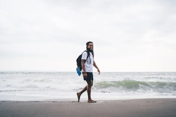 Sırt Çantalı Sırtüstü Gülümseyen Deniz Kıyısında Kameraya Bakan Afro Amerikan — Stok fotoğraf