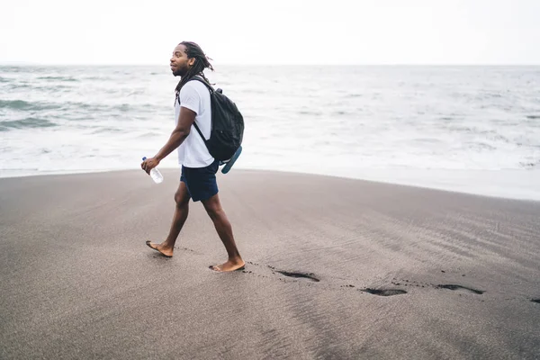 각도의 긍정적 아프리카 미국인 해변에 물병을 배낭을 — 스톡 사진