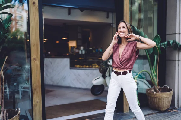 Overjoyed Caucasian Female Trendy Wear Walking City Street Talking Mobile — Fotografia de Stock