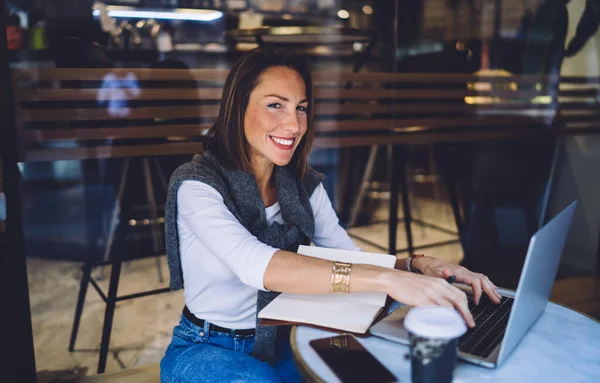 Gülümseyen Beyaz Kadın Dizüstü Bilgisayarda Yazı Yazıyor Mesafeli Işten Kablosuz — Stok fotoğraf