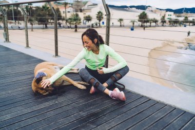 Kıyıdaki iskelede morgel hayvanıyla güzel vakit geçiren güzel bir kadın. Oldukça fit bir kız. Sabahları safkan köpeği eğlendirip eğitmekten zevk alıyor.