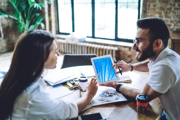 Young Male Female Colleagues Discussing Business Issues Using Tablet While — Stock Photo, Image