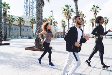 Deneyimli sporcular sabah kardiyo egzersizlerinin keyfini çıkarırlar, çok ırklı sporcular sağlıklı bir yaşam tarzı sürdürmek için fiziksel takım çalışması sırasında dinlenirler.