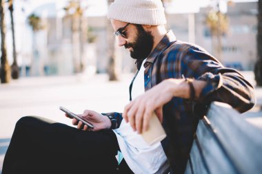 Güneş gözlüklü ve modaya uygun şapka kontrolü yapan Orta Doğulu erkek blogcu şehirde boş zamanlarında 4g internet kullanan bir e-posta aldı.