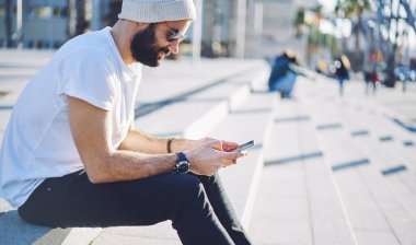 Türk seyahat blogcusu, tatillerde gezici İnternet kullanan ağ takipçileriyle yaptığı akıllı telefon mesajları sırasında arıyor, cep telefonu teknolojisiyle güneş gözlüğü tarayıcı web sitesinde bin yıllık hipster adam