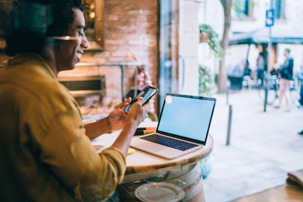 Glass Side View Cheerful Ethnic Male Freelancer Using Smartphone While — Stock Photo, Image