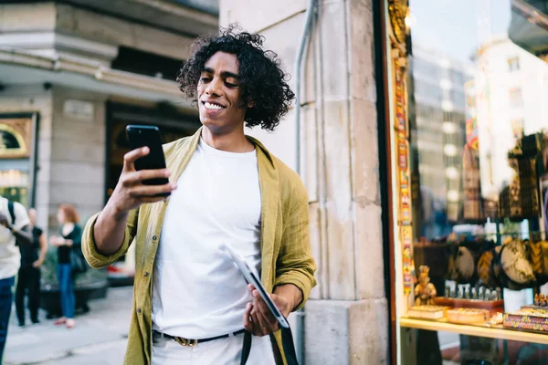 Cheerful Young Male Curly Hair Using Mobile Phone Sending Messages — Stockfoto