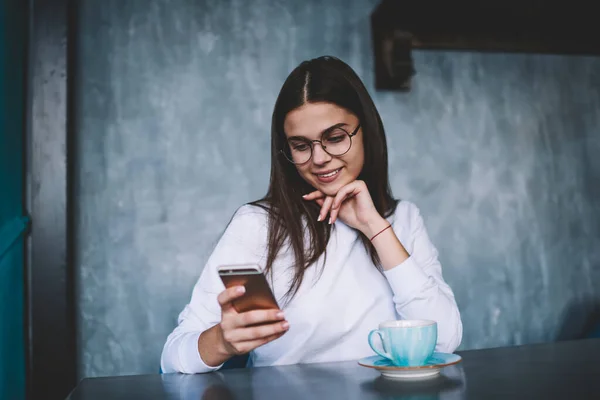 Uzun Saçlı Gözlüklü Neşeli Kadın Bir Fincan Kahve Cep Telefonuyla — Stok fotoğraf