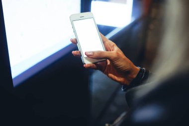 Yukarıda tanımlanamayan bir kadın cep telefonuna dokunuyor ve akşamları şehir caddesinde vakit geçirirken mesaj gönderiyor.