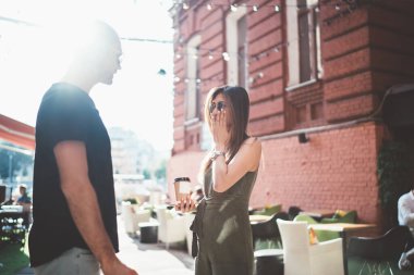 Farklı erkek ve kadın kankaların kentteki kahve saatlerinde eğlencenin tartışıldığı arka plan manzarası, birbirine aşık çok kültürlü bir çift birlikte seyahat ederken günlük kıyafetlerini giyip sohbet ediyorlar.