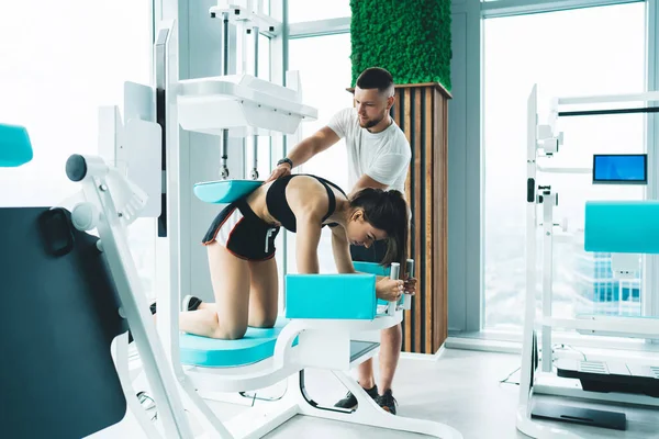 Full Body Concentrated Young Sportsman Assisting Woman Doing Correct Exercise — Stockfoto