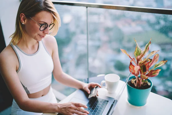 High Angle Friendly Young Woman Booking Hotel Using Bank Card — ストック写真