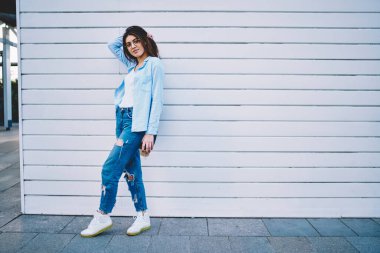 Tam boy beyaz kadın portresi. Günlük giysiler içinde 20 yaşında. Açık havada poz veren çekici bir hippi kız.