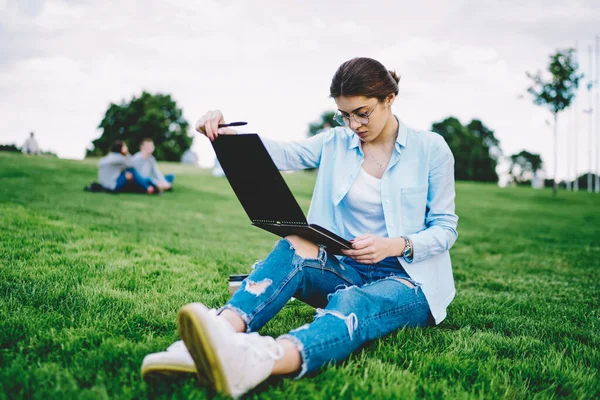 聪明的女学生 戴着光学眼镜 阅读备考汇编 坐在草地上思考问题 戴着眼镜沉思嬉皮士 一边学习一边思考教育问题 — 图库照片