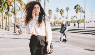 Mutlu hippi kız en iyi arkadaşını aramak ve uluslararası seyahatleri tartışmak için mobil cihaz kullanıyor, akıllı telefon cihazlı neşeli bayan turist pozitif cep telefonu sohbeti yapıyor