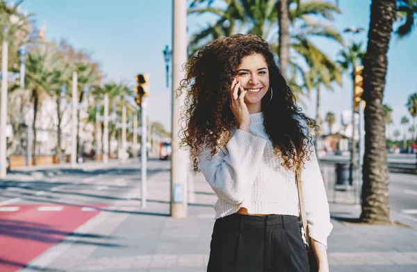 Portrait Cheerful Female Tourist Curly Hair Smiling Camera While Using — Stock fotografie