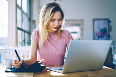 Kafkasyalı, netbook bilgisayarı olan beyaz bir kız öğrenci kafeteryada öğrenme ve mesajlaşma, modern laptop teknolojisini kullanarak içerideki 4G kablosuz internet bağlantısını izleyen yetenekli bir kadın.