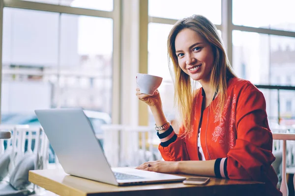 Portrait Cheerful Female Copywriter Cup Tasty Coffee Smiling Camera Using — стоковое фото