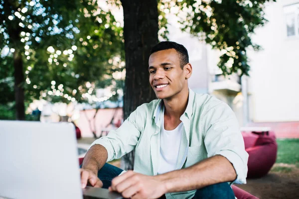 Joven Freelancer Negro Alegre Sentado Cafetería Comodidad Situada Parque Trabajando — Foto de Stock