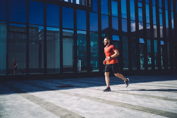 Şehirdeki Kaldırımda Koşan Spor Ayakkabılı Bir Adam Cam Binaya Doğru — Stok fotoğraf