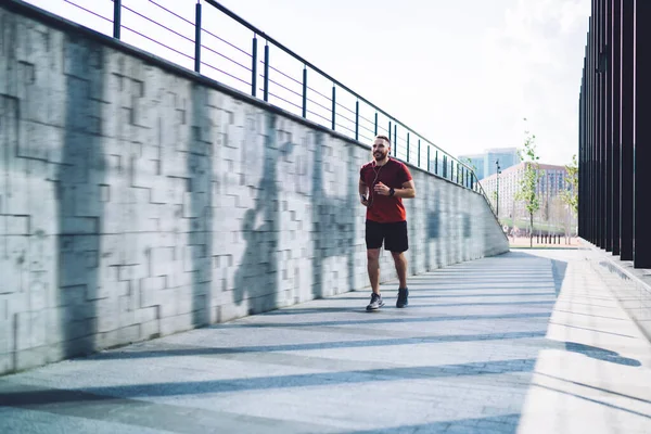 Full Length Young Sportsman Jogging Pavement Using Earphones Music While — Stock Photo, Image