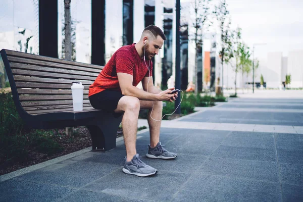Side View Serious Bearded Sportsman Activewear Browsing Mobile Phone Listening — Foto de Stock