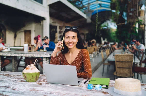 幸せなアジアの女性のフリーランスは ビジネスプロジェクトやラップトップを使用している間 テーブルに座って携帯電話で話をする — ストック写真