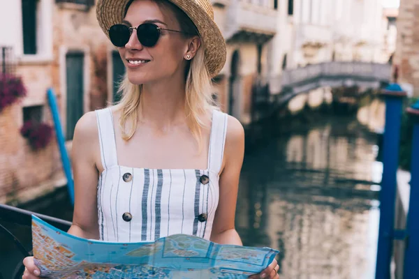 イタリアの晴れた日の週末に紙の地図を保持しながら 古代建築の絵のような景色を楽しむ楽観的な女性観光客 — ストック写真