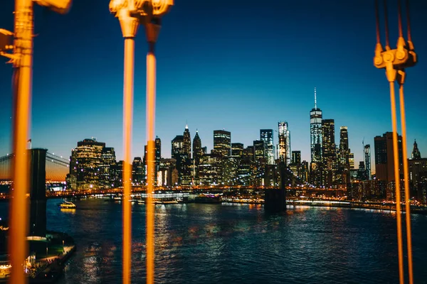 布鲁克林大桥的夜景 以及曼哈顿大桥前方用吊索照明的纽约摩天大楼 — 图库照片